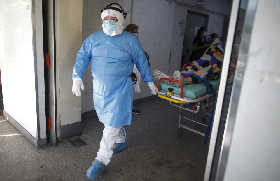 Un médico traslada a un paciente con COVID-19 a una ambulancia para ser transferido a otro hospital el martes 13 de abril de 2021, en Avellaneda, Argentina. (AP Foto/Natacha Pisarenko)