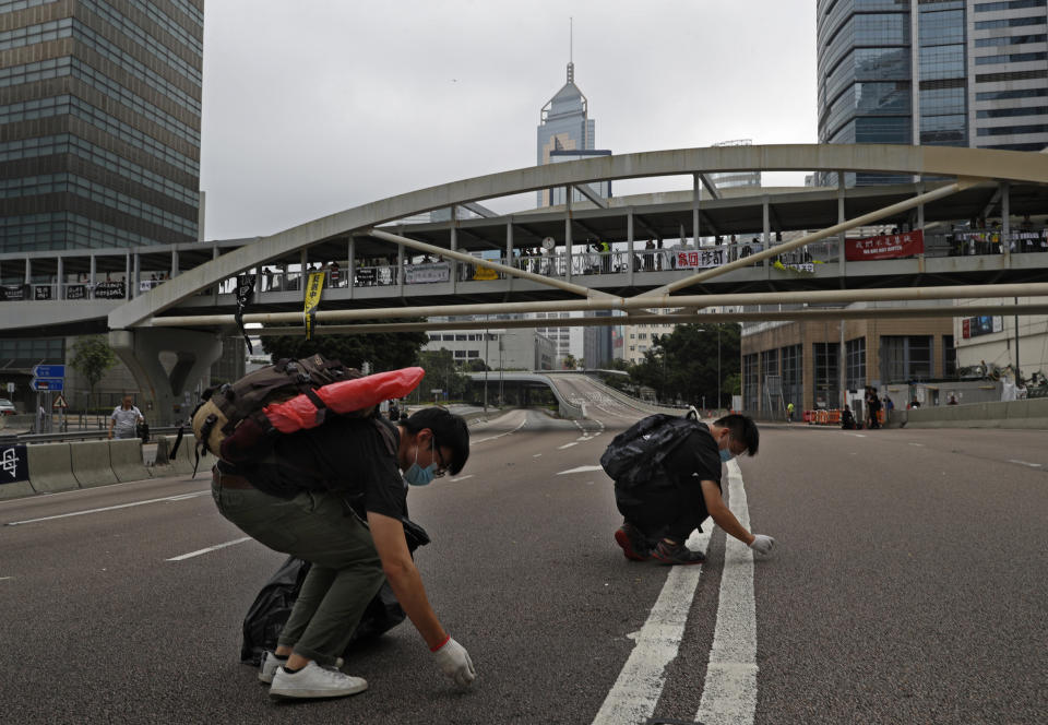 Protesters clean up the main road near the Legislative Council after tens of thousands of protesters staged a massive protest against an extradition bill in Hong Kong, Monday, June 17, 2019. Protesters in Hong Kong have begun leaving the streets and gathering near the city's government headquarters. (AP Photo/Vincent Yu)