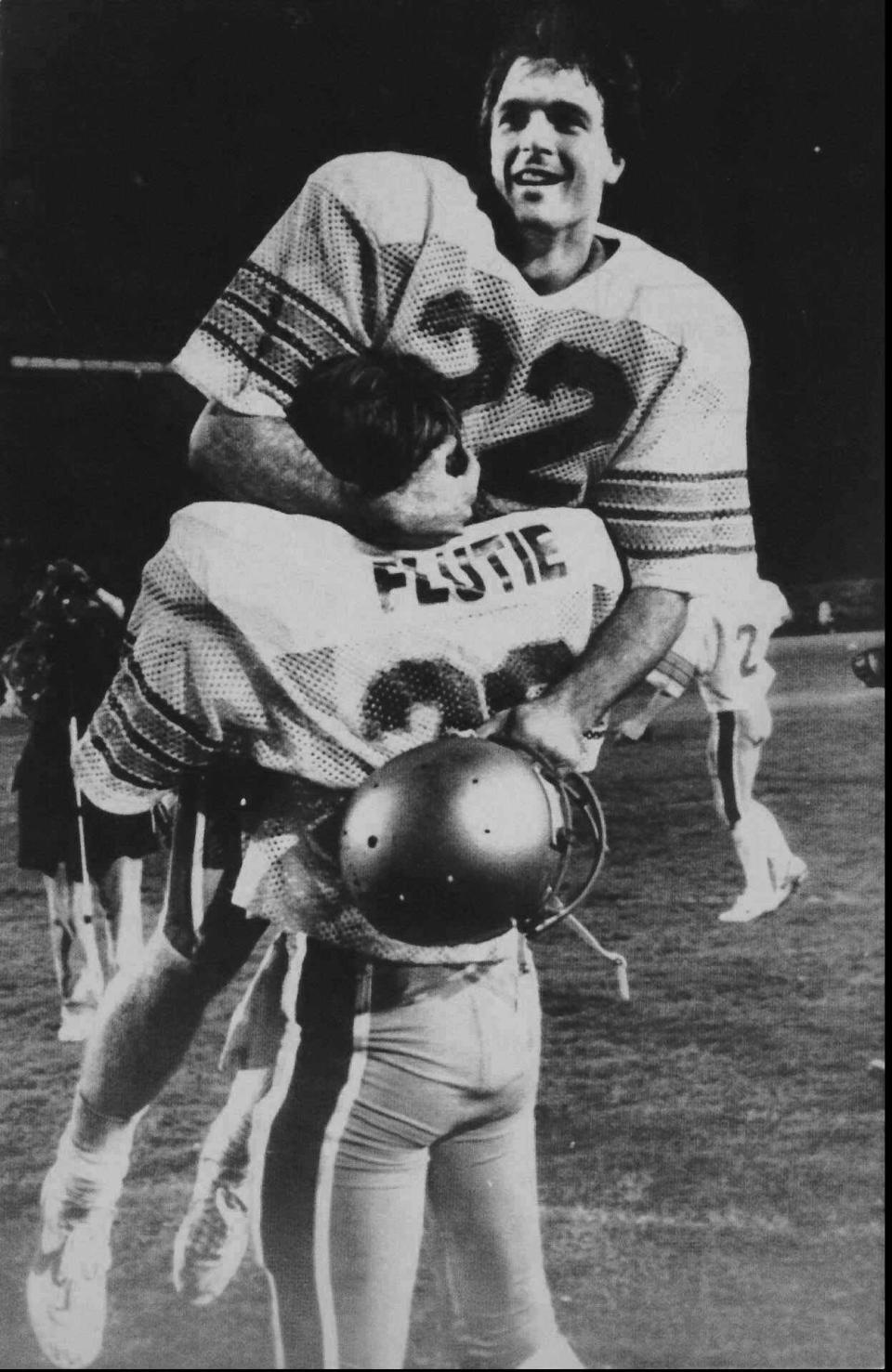 FILE - Boston College quarterback Doug Flutie rejoices in his brother Darren's arms after B.C. defeats the Miami Hurricanes with a last second touchdown pass in Miami on Nov. 23, 1984. Famous football plays often attain a legendary status with religious names like the "Immaculate Reception," the "Hail Mary" pass and the Holy Roller fumble. (AP Photo, File)
