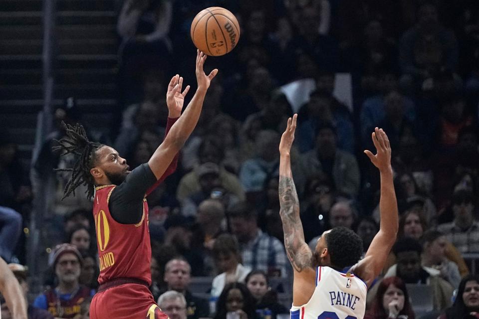 Cleveland Cavaliers guard Darius Garland, left, shoots over Philadelphia 76ers guard Cameron Payne, right, in the first half of an NBA basketball game, Monday, Feb. 12, 2024, in Cleveland. (AP Photo/Sue Ogrocki)