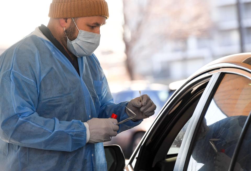 Medical testing technician Zach Dynes provides a COVID-19 test on Wednesday, January 12, 2022, outside the Avera Institute for Human Genetics in Sioux Falls.