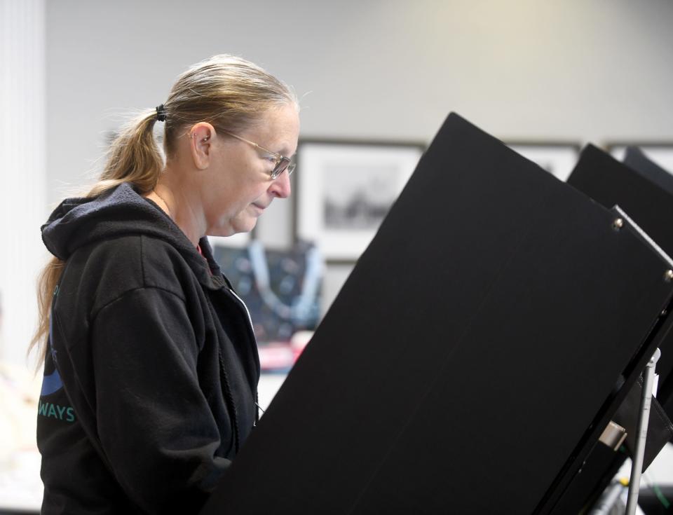 Lorena Whaley looks over her ballot Tuesday while voting at the Massillon Public Library.