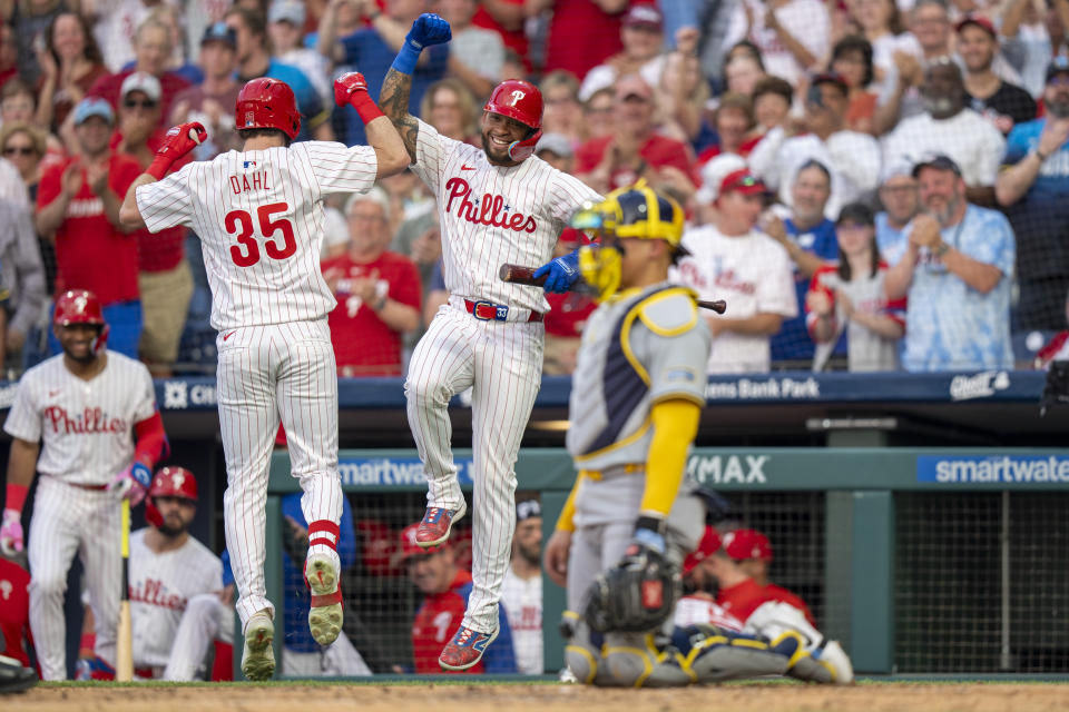 Philadelphia Phillies' David Dahl (35) reacts after his home run with Johan Rojas, center, as Milwaukee Brewers catcher William Contreras, right, looks on during the fourth inning of a baseball game, Monday, June 3, 2024, in Philadelphia. (AP Photo/Chris Szagola)