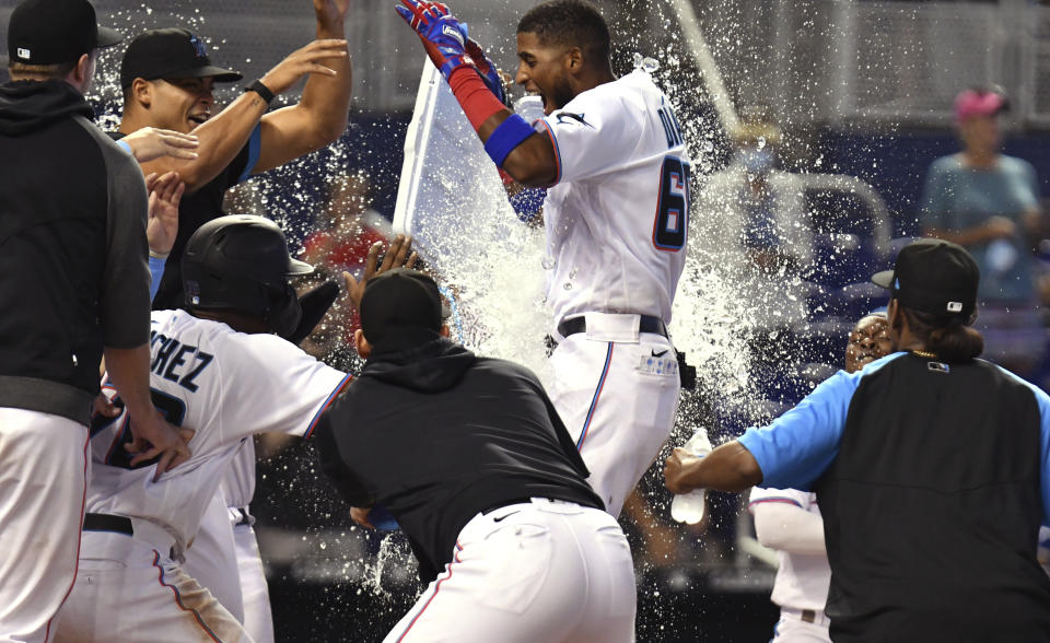 Miami Marlins' Lewin Diaz, center, celebrates with teammates after hitting a two-run walkoff home run against the Pittsburgh Pirates in the 10th inning of a baseball game, Sunday, Sept. 19, 2021, in Miami. (AP Photo/Jim Rassol)