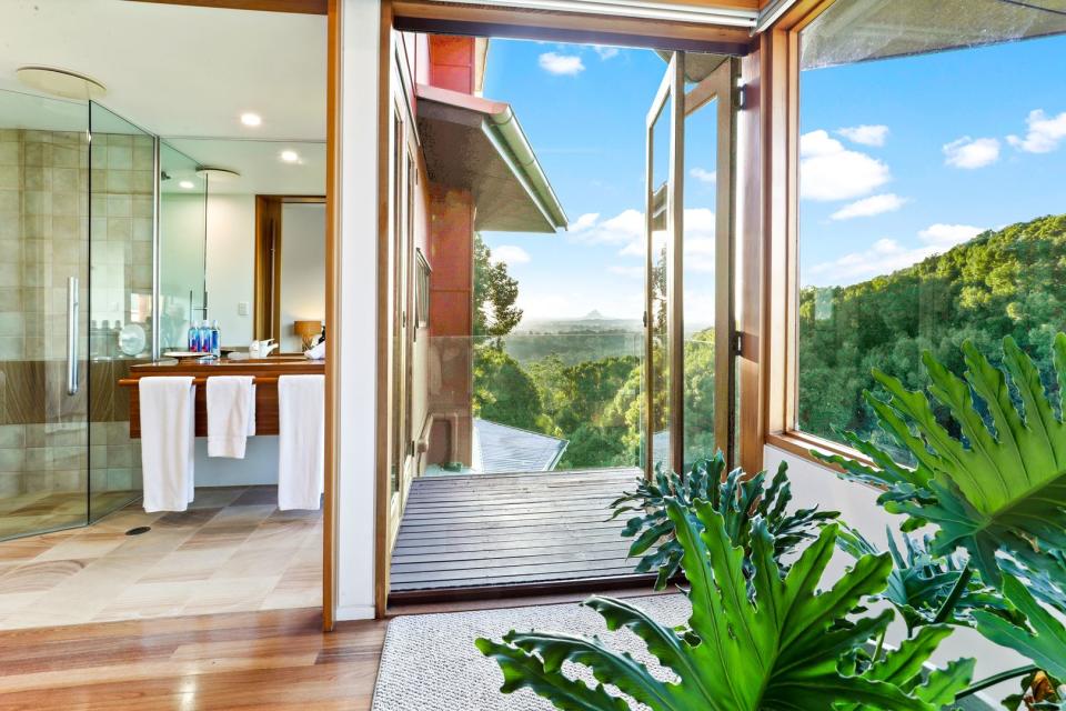 A view from the bath room stretching as far as the eye can see with rolling hills and lush rain forest