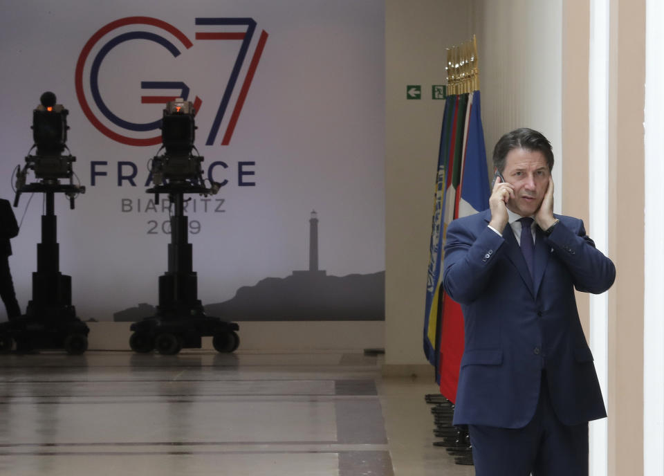 Italian Premier Giuseppe Conte speaks on the phone on the second day of the G-7 summit in Biarritz, France Sunday, Aug. 25, 2019. (AP Photo/Markus Schreiber)