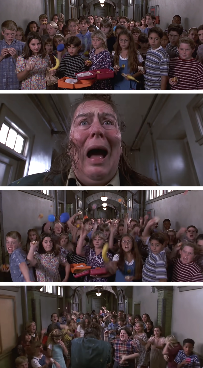 Miss Trunchbull looks terrified as children celebrate around her in a school hallway