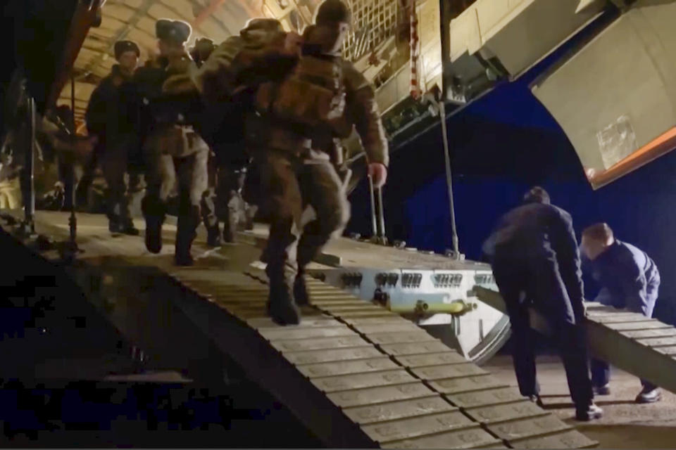 In this image taken from footage provided by the RU-RTR Russian television, Russian peacekeepers exit a Russian military plane in an airport in Kazakhstan, Thursday, Jan. 6, 2022. A Russia-led military alliance, the Collective Security Treaty Organization, said early Thursday that it would send peacekeeper troops to Kazakhstan at the request of President Kassym-Jomart Tokayev. (RU-RTR Russian Television via AP)