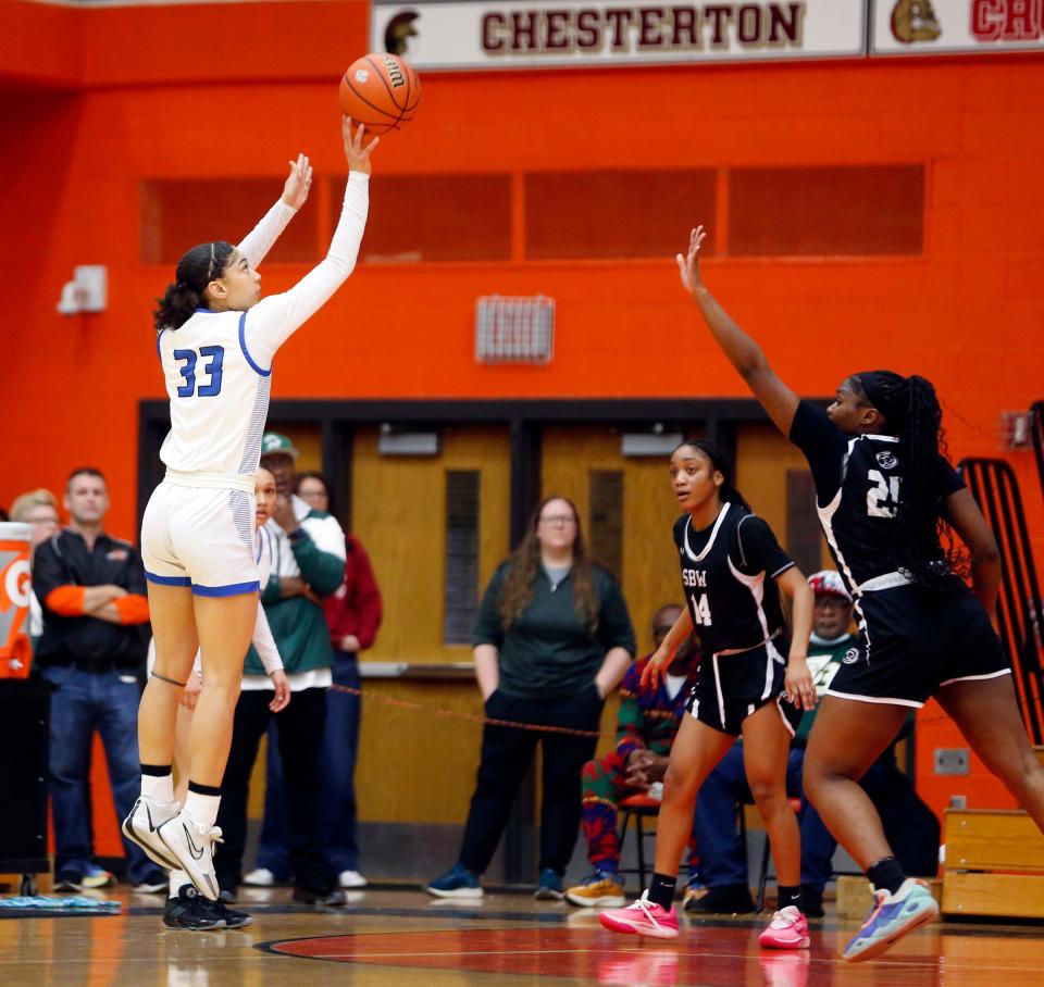 Lake Central senior Anyiah Bishop (33) shoots a '3' as Washington junior Ayanna Nicholson closes in on defense during a Class 4A regional girls basketball championship game Saturday, Feb. 10, 2024, at LaPorte High School.