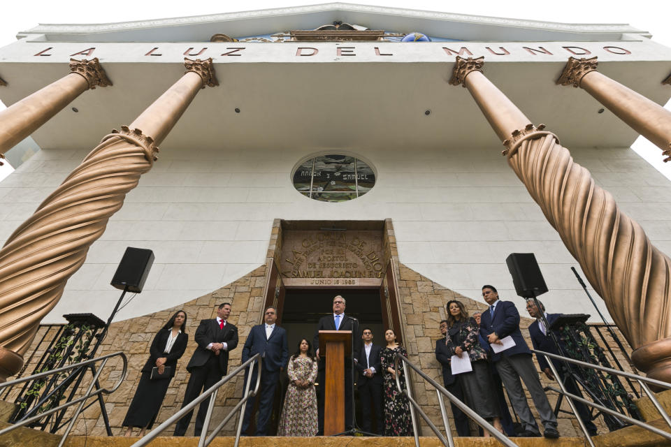 La Luz Del Mundo minister Jack Freeman, who has been with the Mexico-based megachurch for 27 years, at podium, introduces the new lawyers for the leader of a Mexico-based megachurch La Luz del Mundo leader Naasón Joaquín García, at a news conference outside the East Los Angeles temple of La Luz del Mundo, Friday, June 7, 2019. Attorneys Ken Rosenfeld, second from left, and Allen Sawyer, third from left, are flanked by the leader's family and other church members. (AP Photo/Damian Dovarganes)