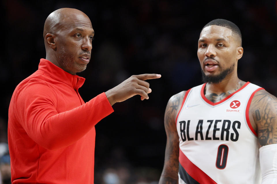 Chauncey Billups and Damian Lillard talk on the sideline during a game.