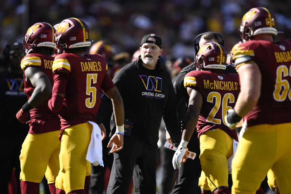 Washington Commanders head coach Dan Quinn, center, celebrates with players after a touchdown against the Cleveland Browns during the second half of an NFL football game in Landover, Md., Sunday, Oct. 6, 2024. (AP Photo/Nick Wass)