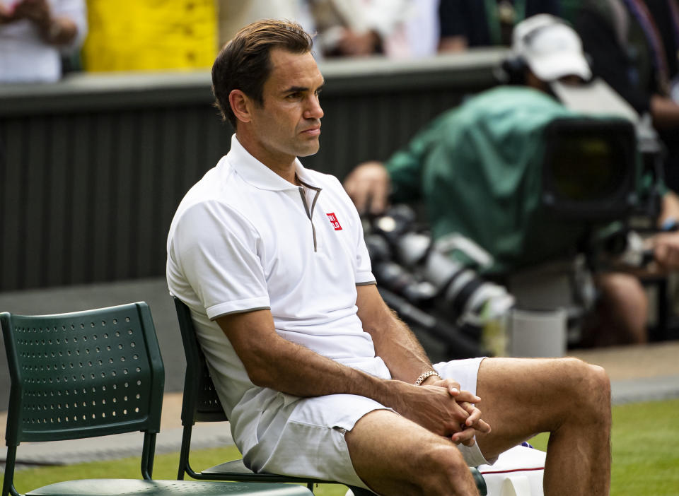 Roger Federer looks dejected and sits down after losing against Novak Djokovic.