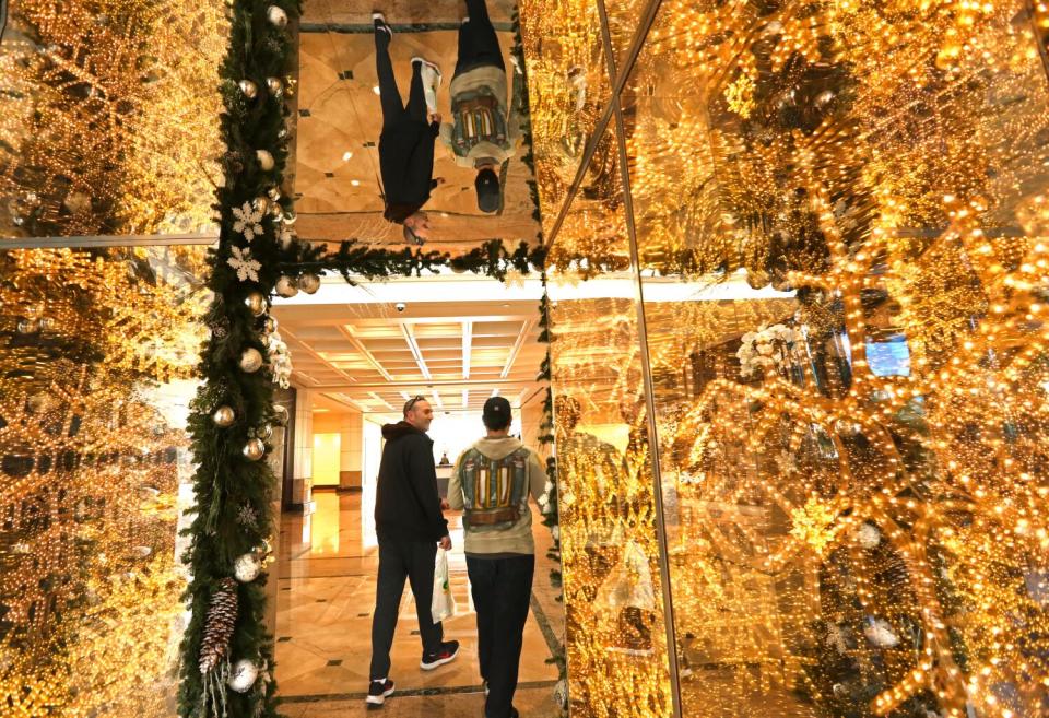 Workers are framed by a holiday lobby display inside the Water Garden office complex in Santa Monica.