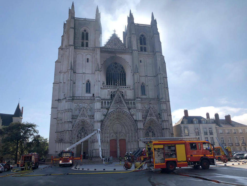 Fire fighters brigade work to extinguish the blaze at the Gothic St. Peter and St. Paul Cathedral, in Nantes, western France, Saturday, July 18, 2020. The fire broke, shattering stained glass windows and sending black smoke spewing from between its two towers of the 15th century, which also suffered a serious fire in 1972. The fire is bringing back memories of the devastating blaze in Notre Dame Cathedral in Paris last year that destroyed its roof and collapsed its spire and threatened to topple the medieval monument. (AP Photo/Laetitia Notarianni)