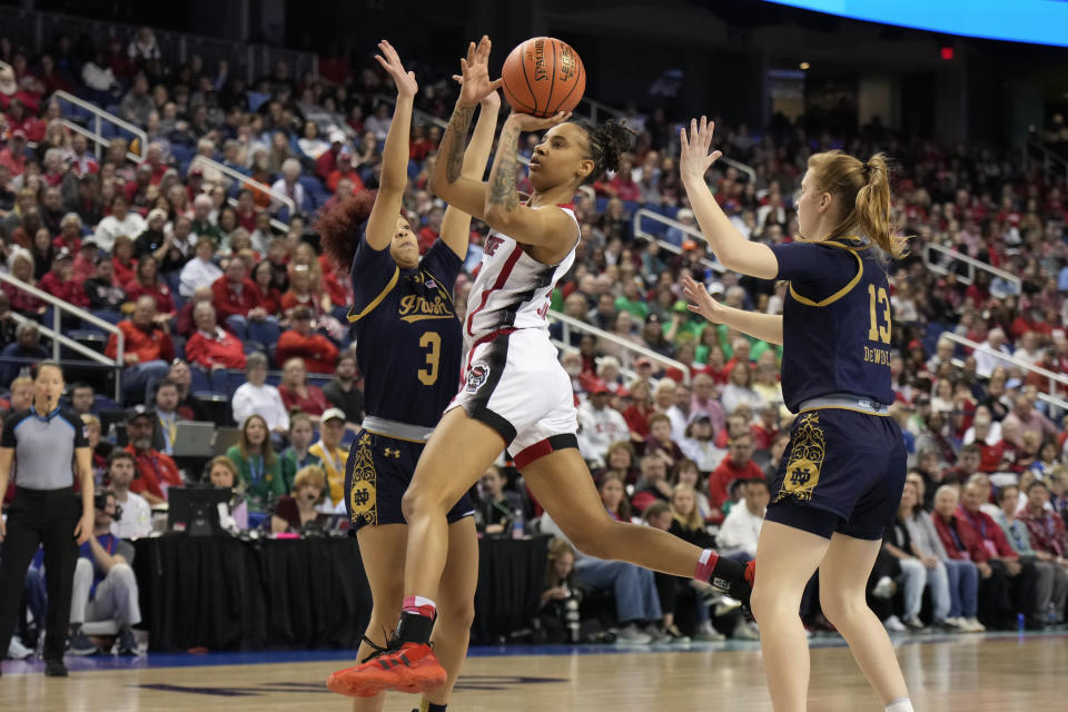 NC State's Aziaha James, center, shoots between Notre Dame's Hannah Hidalgo (3) and Anna DeWolfe (13) during the first half of an NCAA basketball game for the Women's Atlantic Coast Conference championship in Greensboro, N.C., Sunday, March 10, 2024. (AP Photo/Chuck Burton)