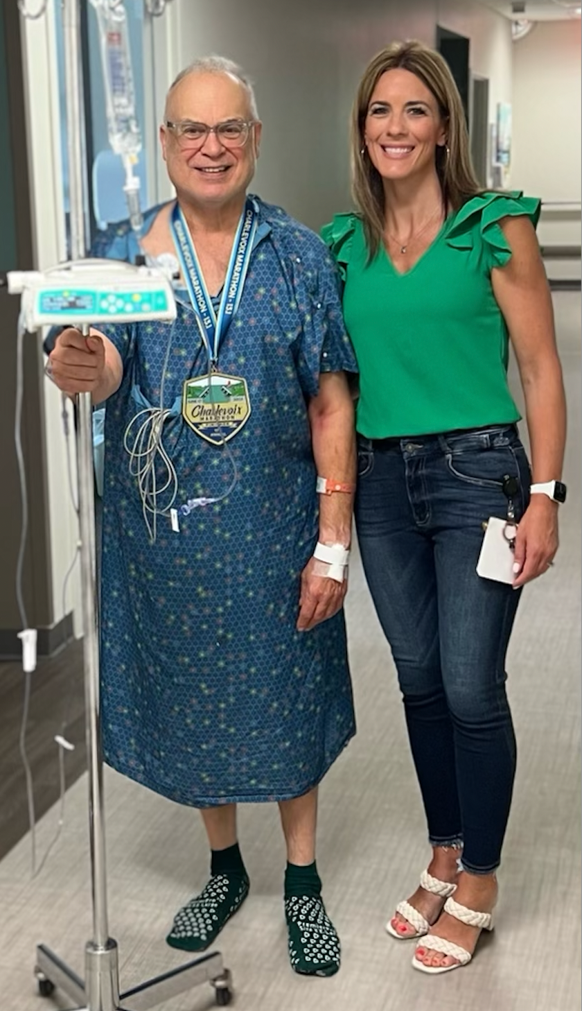 Richard Mayer (left) smiling with the woman who saved his life, Heather Lewis, as he recovers in McLaren Northern Michigan hospital after suffering a heart attack on June 17 during the Charlevoix Marathon.