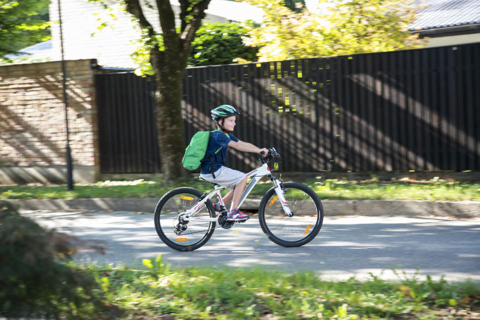 Junge mit Rucksack fährt Fahrrad
