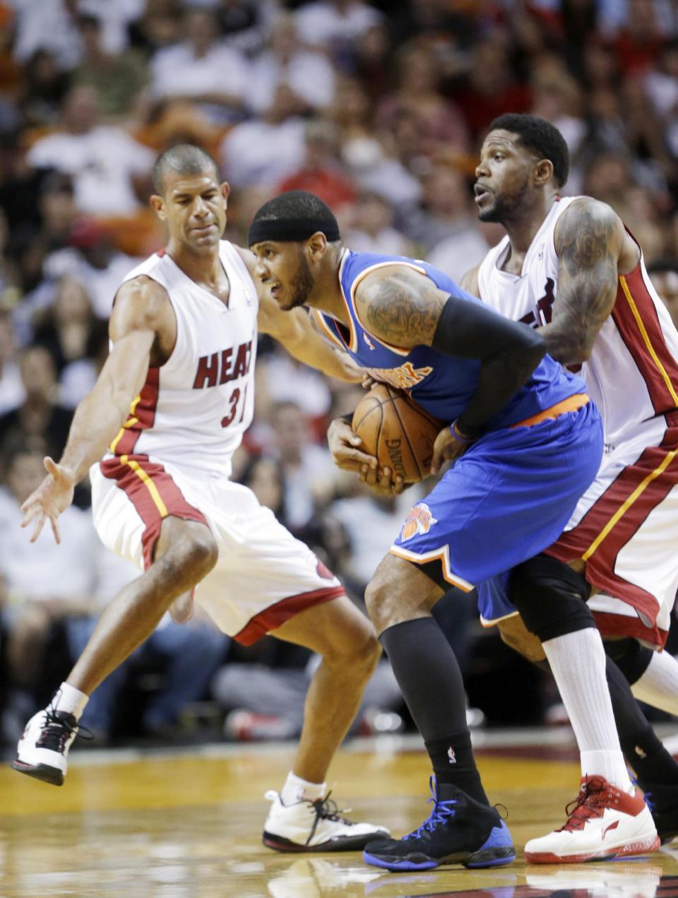 New York Knicks forward Carmelo Anthony, center, is fouled by Miami Heat forward Udonis Haslem, right, as forward Shane Battier, left, defends during the first half of an NBA basketball game, Sunday, April 6, 2014, in Miami. (AP Photo/Wilfredo Lee)