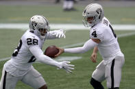 Las Vegas Raiders quarterback Derek Carr (4) hands off to running back Josh Jacobs (28) in the first half of an NFL football game against the New England Patriots, Sunday, Sept. 27, 2020, in Foxborough, Mass. (AP Photo/Charles Krupa)