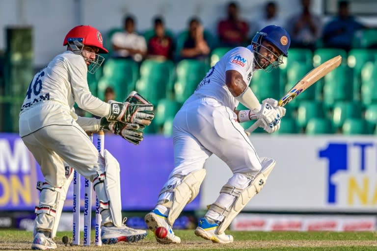 Sri Lanka's Dimuth Karunaratne (R) plays a shot as Afghanistan's wicketkeeper Ikram Alikhil watches during the first day of the one-off Test cricket match between Sri Lanka and Afghanistan in Colombo (Ishara S. KODIKARA)