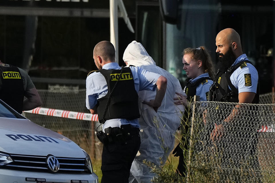 Una persona vestida de blanco es escoltada por la policía cerca del centro comercial Field's luego de un tiroteo, el domingo 3 de julio de 2022, en Copenhague. (Claus Bech/Ritzau Scanpix via AP)