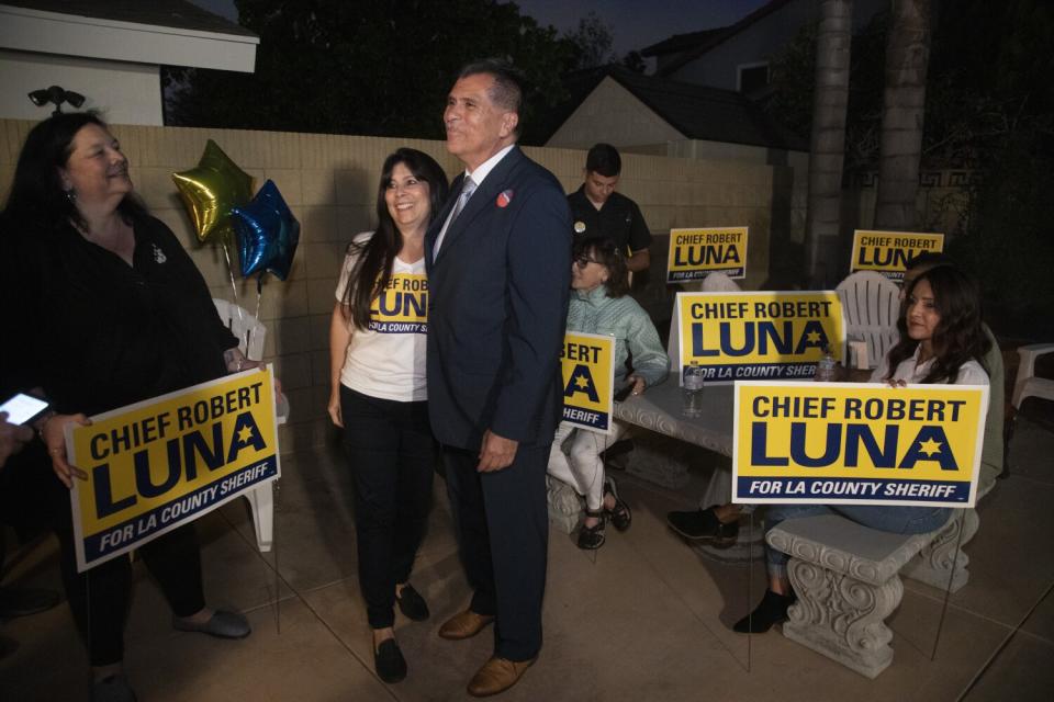 Robert Luna and wife Celines surrounded by supporters with election signs on a patio