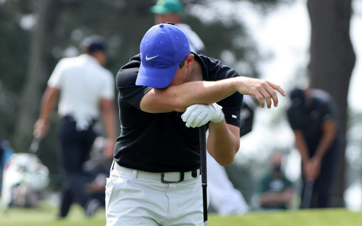 Rory McIlroy buries his head in his arm - REUTERS