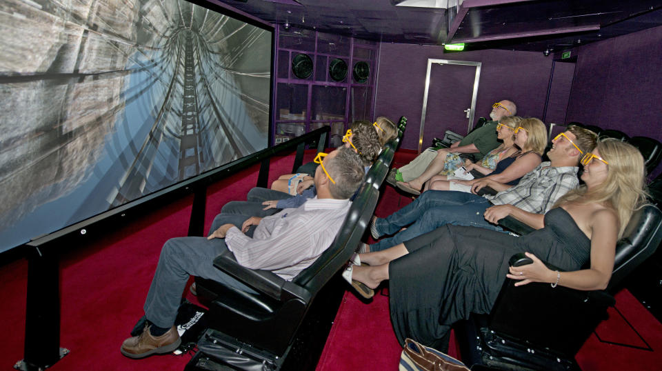 In this June 17, 2012 photo provided by Carnival Cruise Lines, guests onboard Carnival Breeze enjoy the Thrill Theater, an interactive, multi-dimensional experience that makes them feel as if they are part of the movie. Among various sensory effects, seats shift back and forth, move from side to side and also vibrate, creating an exciting and exhilarating experience. (AP Photo/Carnival Cruise Lines, Andy Newman)
