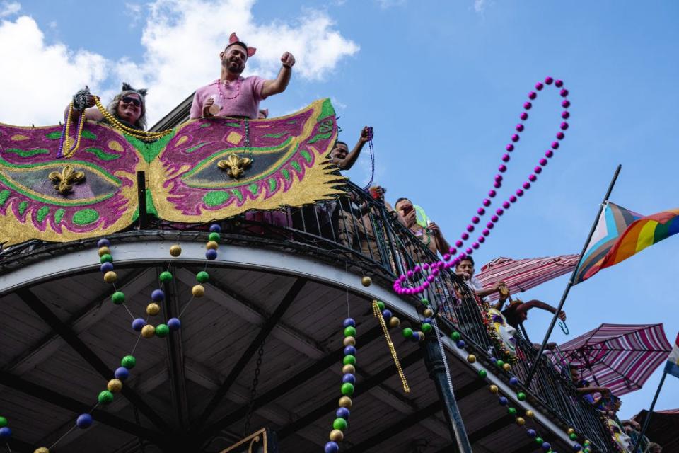 Mardi Gras attendees throw beads to people on the street in the French Quarter on Feb. 21, 2023 in New Orleans.