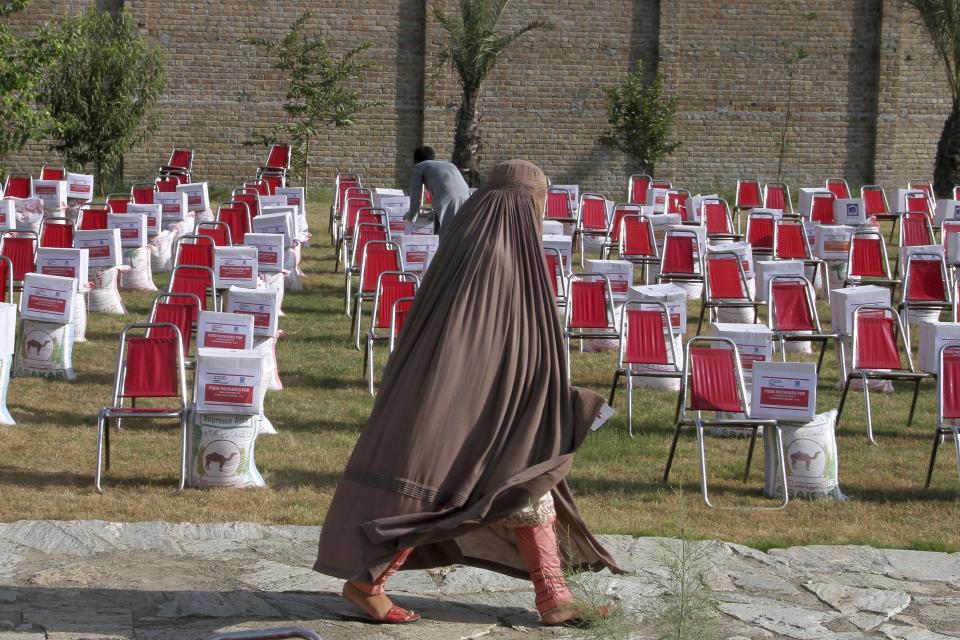 A woman from a flood affected area arrives to receive food and other items distributed by the religious charity group Al-Khidmat Foundation Pakistan, in Shabqadar near Peshawar, Pakistan, Tuesday, Sept. 13, 2022. The death toll from three months of record-breaking floods in Pakistan rose to over 1,400, officials said Tuesday, as the minister for climate warned the prolonged monsoon rains will continue lashing this impoverished nation in the coming weeks. (AP Photo/Muhammad Sajjad)