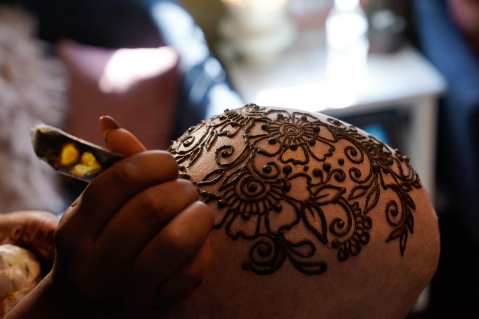 Traditional floral patterns fill Bernice Schwartzman's head as part of henna crown applied by Vidhi Heiland on Friday. Heiland's business, Essential Henna, has started offering her work for free to those who have lost their hair because of cancer.