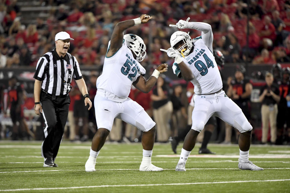 Coastal Carolina defenders C.J. Brewer (52) and Jeffrey Gunter (94) celebrate after sacking Arkansas State quarterback James Blackman during the first half of an NCAA college football game Thursday, Oct. 7, 2021, in Jonesboro, Ark. (AP Photo/Michael Woods)