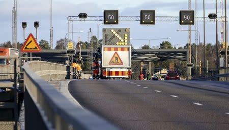 Service personnel repair a gate, where a car drove through before crashing into the canal under the E4 highway bridge in Sodertalje, Sweden, February 13, 2016. REUTERS Johan Nilsson / TT News Agency