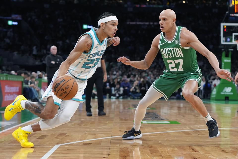 Charlotte Hornets' Tre Mann (23) drives past Boston Celtics' Jordan Walsh (27) during the first half of an NBA basketball game, Friday, April 12, 2024, in Boston. (AP Photo/Michael Dwyer)