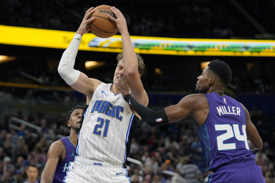 Orlando Magic center Moritz Wagner (21) struggles to get control of a pass against Charlotte Hornets forward Brandon Miller (24) during the first half of an NBA basketball game, Sunday, Nov. 26, 2023, in Orlando, Fla. (AP Photo/John Raoux)