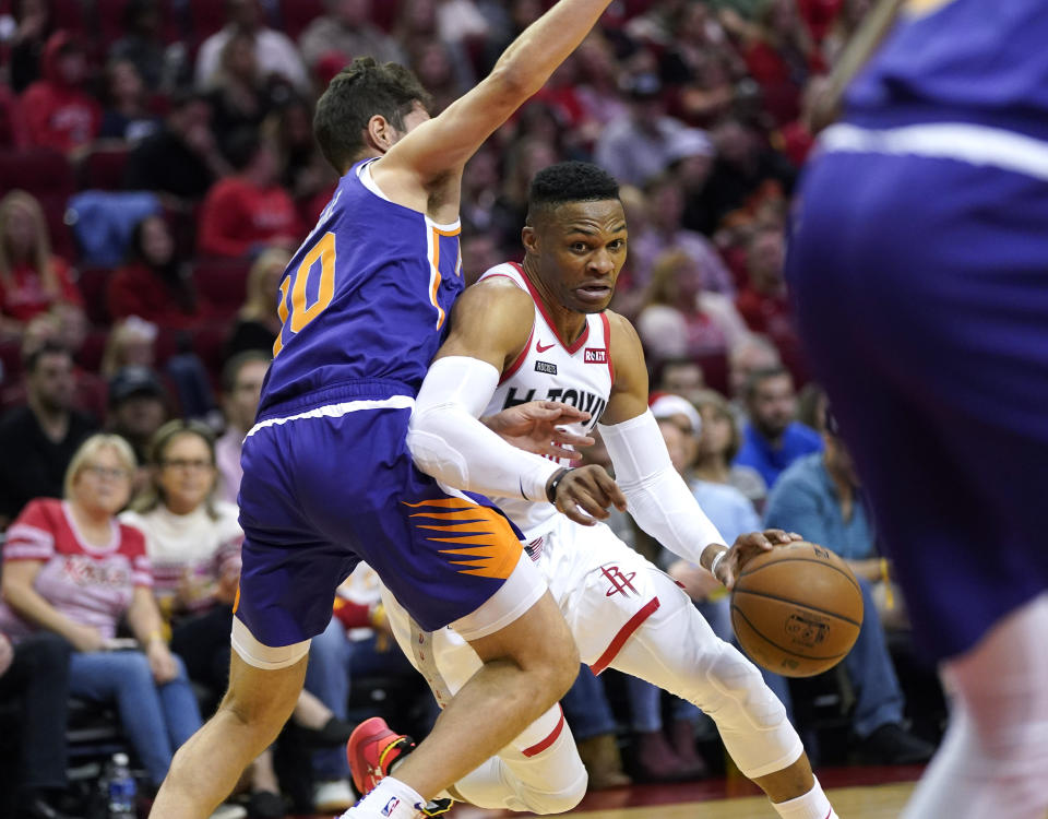 Houston Rockets' Russell Westbrook, right, drives toward the basket as Phoenix Suns' Ty Jerome (10) defends during the first half of an NBA basketball game Saturday, Dec. 7, 2019, in Houston. (AP Photo/David J. Phillip)