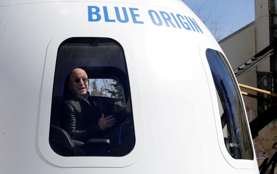 Mr Bezos in Blue Origin's New Shephard rocket booster and Crew Capsule mockup at the 33rd Space Symposium in Colorado Springs - Isaiah Downing/REUTERS