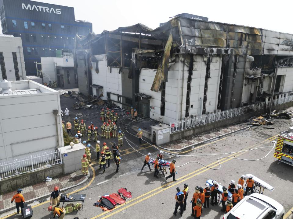 Firefighters carry a body at the site of a fire at a lithium battery manufacturing factory in Hwaseong, South Korea, Monday, June 24, 2024. (Newsis via AP)