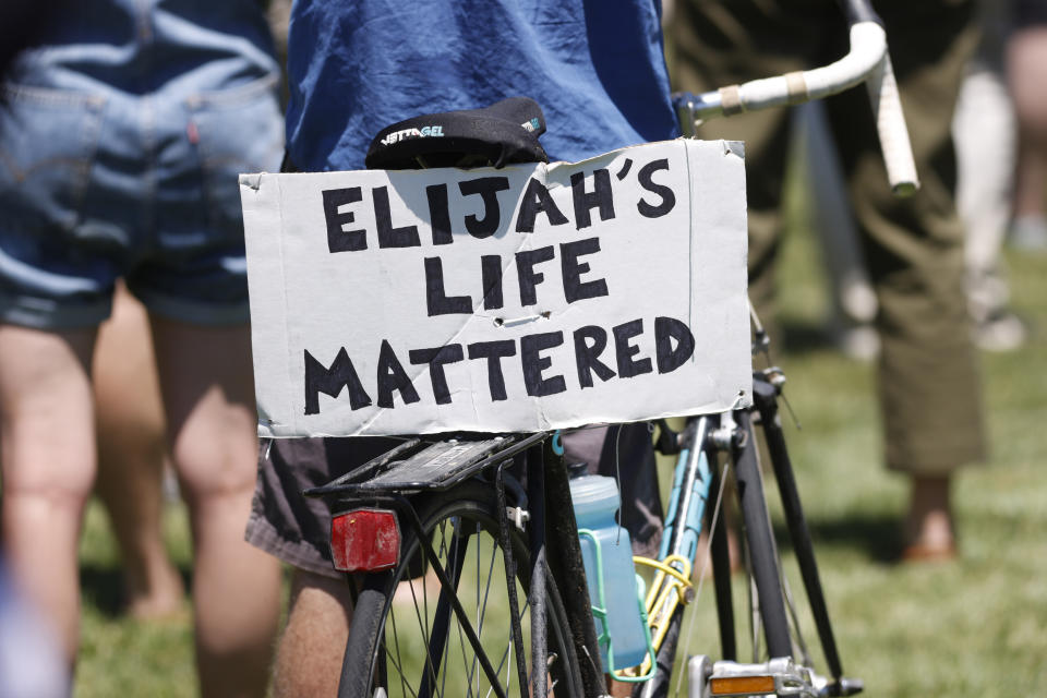 A placard is displayed on a bicycle during a rally and march over the death of 23-year-old Elijah McClain, Saturday, June 27, 2020, outside the police department in Aurora, Colo. McClain died in late August 2019, after he was stopped while walking to his apartment by three Aurora Police Department officers. (AP Photo/David Zalubowski)