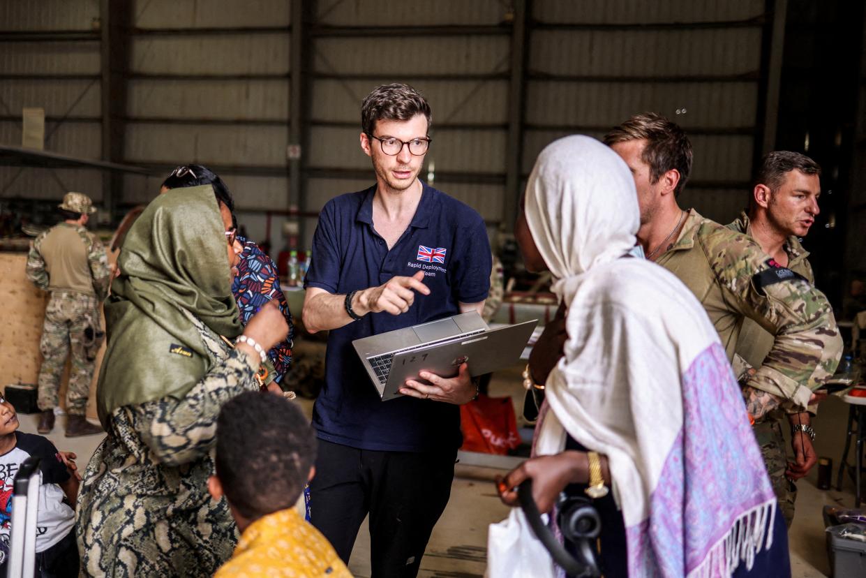 A Foreign and Commonwealth Rapid Response team member helps evacuees before they fly to Cyprus (via REUTERS)