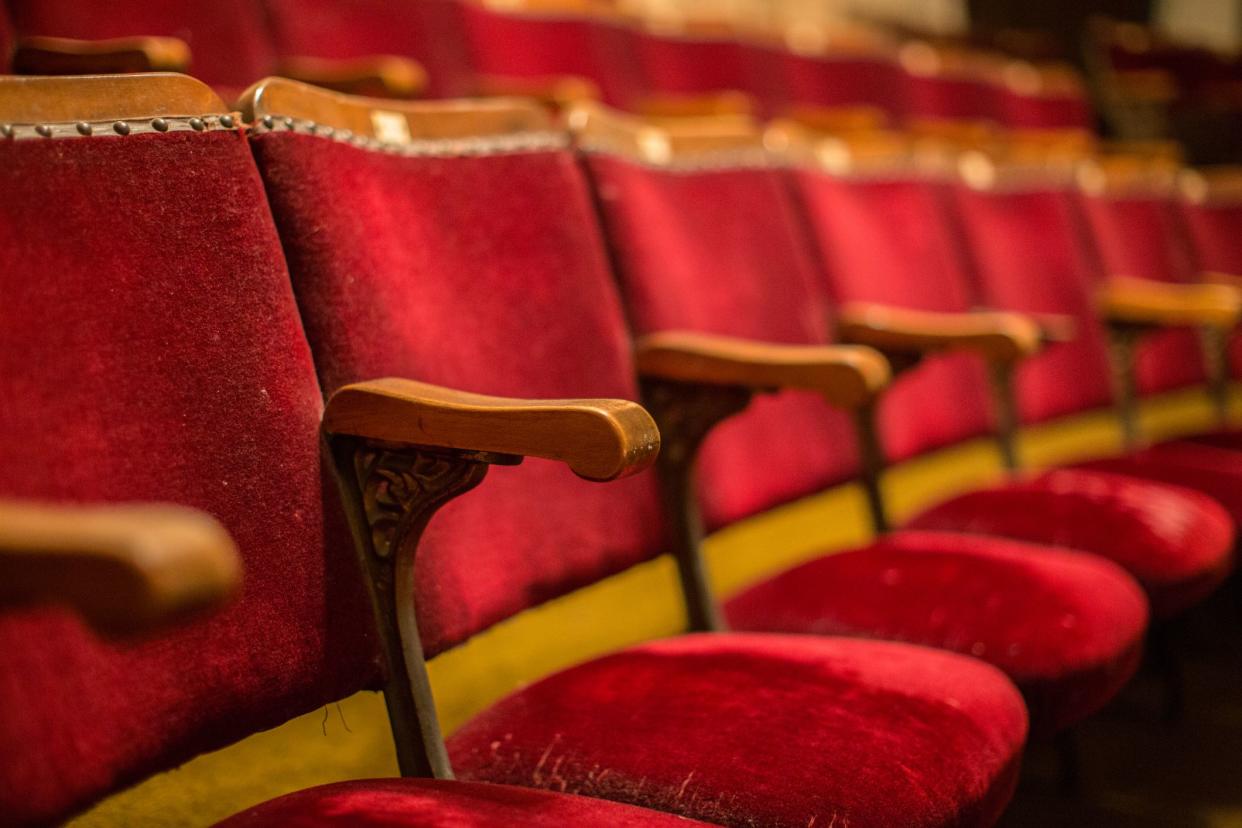 Old fashion cinema theatre seats with wooden arms and flip-up seats