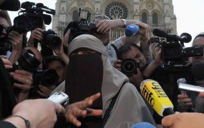 Wearing a niqab, Kenza Drider, the first woman arrested under France's new ban, addresses the media in front of Notre Dame Cathedral on April 11, 2011. (Photo: Pascal Le Segretain/Getty Images) 