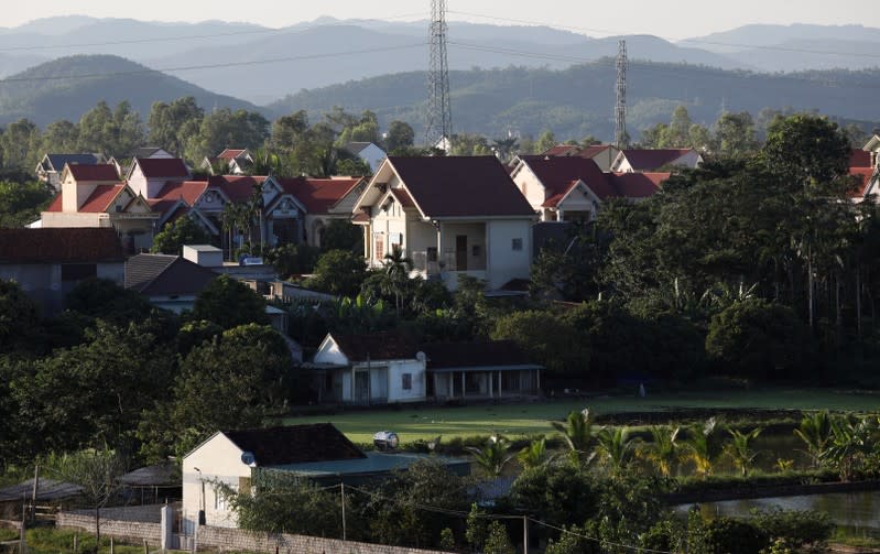 Newly-built houses are seen behind older houses at Do Thanh commune, in Nghe An province