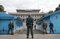 South Korean soldiers look towards the North Korean side as a North Korean solder approaches the U.N. truce village building that sits on the border of the Demilitarized Zone (DMZ), the military border separating the two Koreas, during the visit of U.S. Secretary of Defense Chuck Hagel, in Panmunjom, South Korea September 30, 2013. Hagel toured the Korean DMZ on Monday, at times under the watchful eye of North Korean soldiers, and said the Pentagon had no plan to reduce its 28,500-member force in the South despite budget constraints. (REUTERS/Jacquelyn Martin/Pool)