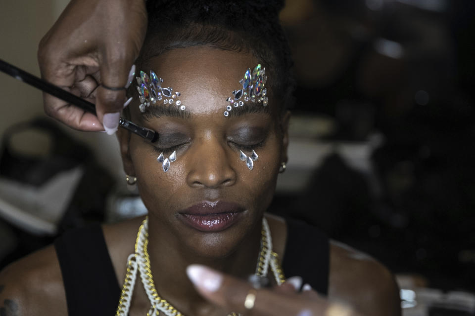 A makeup artist works on a model backstage at the dapperQ fashion show at the Brooklyn Museum on Thursday, Sept. 5, 2019, in New York. (AP Photo/Jeenah Moon)