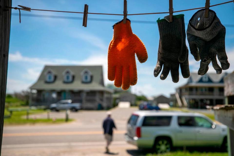 Work gloves, used to clean fish, dry in the morning sun at Jeffrey’s Seafood along NC 12 on Thursday, July 1, 2021 in Hatteras, N.C.