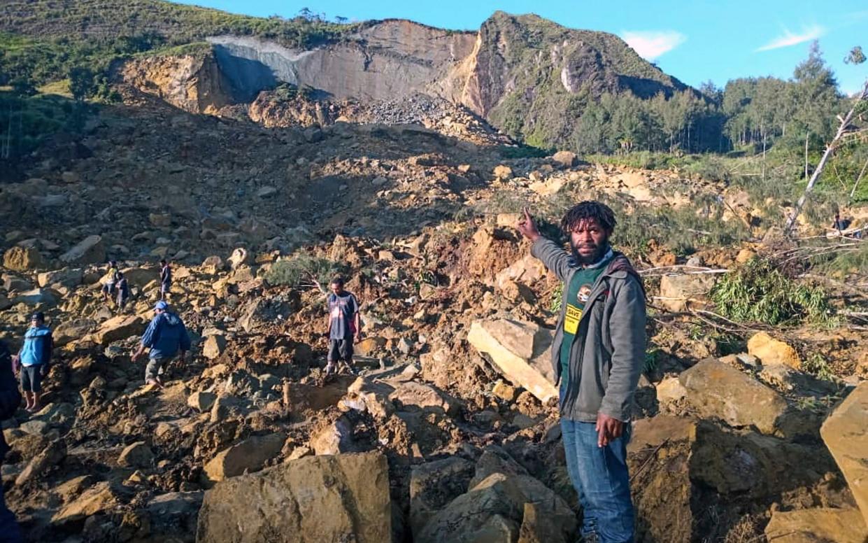 People gather at the site of a landslide in Maip Mulitaka in Papua New Guinea