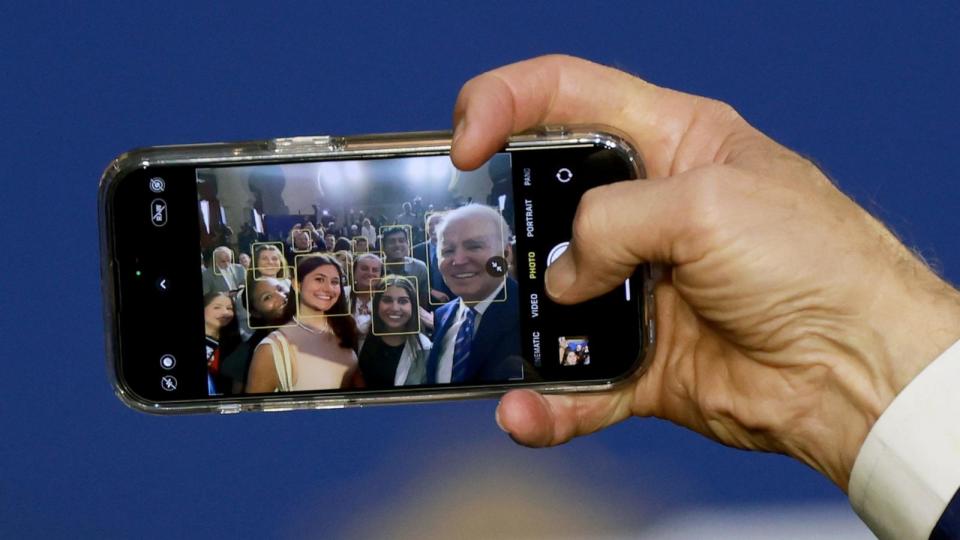 PHOTO: In this Feb. 9, 2023, file photo, President Joe Biden takes a selfie photograph using a guest's phone during an event to discuss Social Security and Medicare held at the University of Tampa , in Tampa, Fla. (Joe Raedle/Getty Images, FILE)