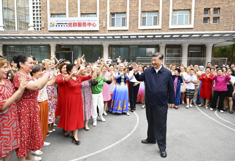 In this photo released by China's Xinhua News Agency, Chinese President Xi Jinping, center, visits the community of Guyuanxiang in the Tianshan District in Urumqi in northwestern China's Xinjiang Uyghur Autonomous Region, Wednesday, July 13, 2022. (Li Xueren/Xinhua via AP)